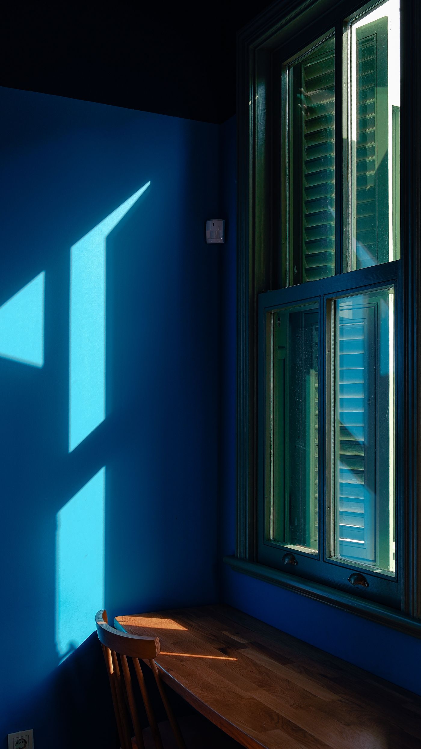 Sash window beside a desk in a blue room